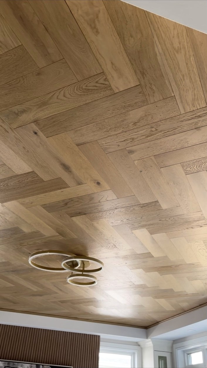 Close-up of a herringbone wood ceiling and light fixture